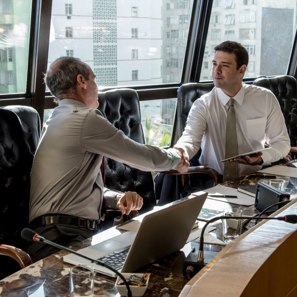 two men shaking hands over commercial deal in brazil